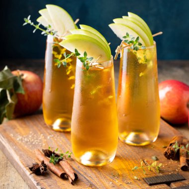Apple cider mimosa for fall brunch, garnished with apple slices, autumn cocktail or mocktail idea