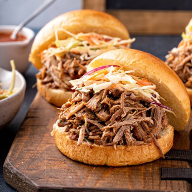 Pulled pork sandwiches with cole slaw and bbq sauce on brioche buns