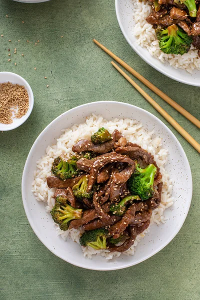 Beef and broccoli stir fry served over rice with sesame seeds top view