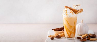 Pumpkin pie crazy milkshake with caramel syrup and whipped cream and a slice of pie on top