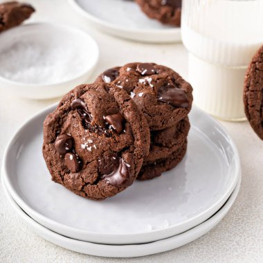 Double chocolate cookies with dark chocolate chips and salt flakes with a glass of milk