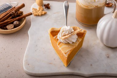 Slice of pumpkin cheesecake swirl pie topped with whipped cream, original Thanksgiving dessert idea