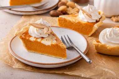 Slice of pumpkin cheesecake swirl pie topped with whipped cream, original Thanksgiving dessert idea
