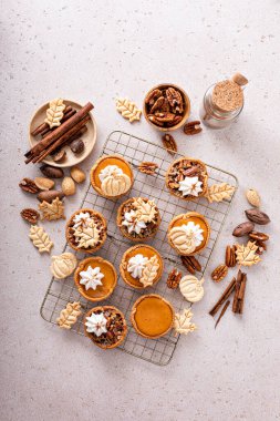 Mini pumpkin and pecan pies baked in muffin tin, traditional Thanksgiving or fall dessert