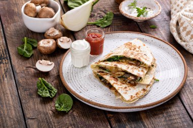 Mushroom, caramelized onion and spinach quesadillas with sour cream and salsa