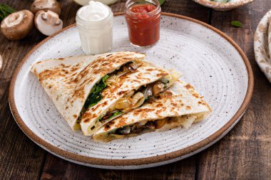 Mushroom, caramelized onion and spinach quesadillas with sour cream and salsa