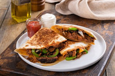 Beef brisket and green pepper quesadillas served with sour cream and salsa