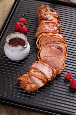 Pork tenderloin wrapped in bacon served with raspberry vinaigrette