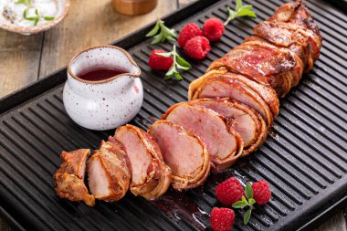 Pork tenderloin wrapped in bacon served with raspberry vinaigrette