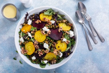 Beet and goat cheese salad with orange dressing and yellow and red beets