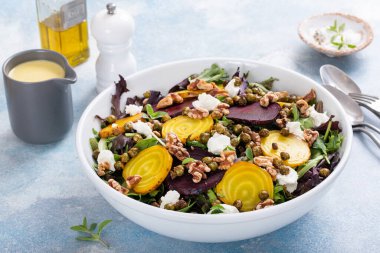 Beet and goat cheese salad with orange dressing and yellow and red beets