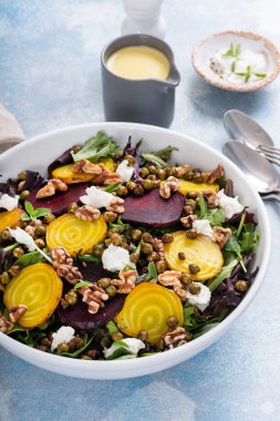 Beet and goat cheese salad with orange dressing and yellow and red beets