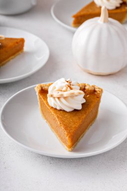 Slices of traditional pumpkin pie in a modern light and bright setting