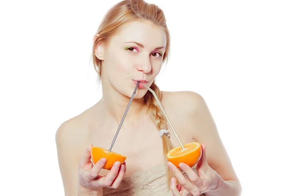 Hermosa joven bebiendo jugo directamente de una fruta de naranja —  Fotos de Stock