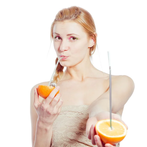 Krásná mladá žena pití šťávy přímo z oranžové ovoce — Stock fotografie