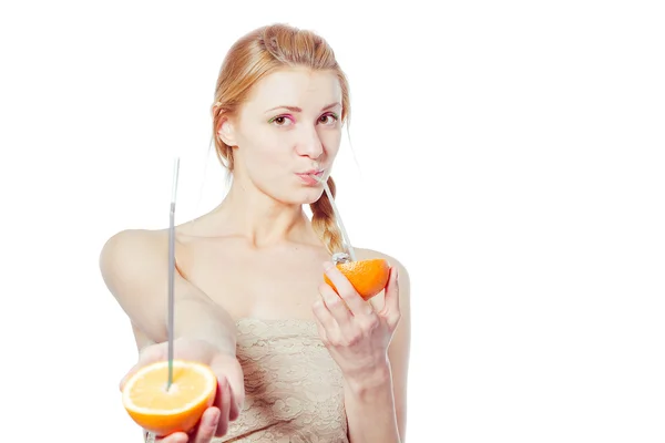 Beautiful young woman drinking juice direct from an orange fruit — Stock Photo, Image