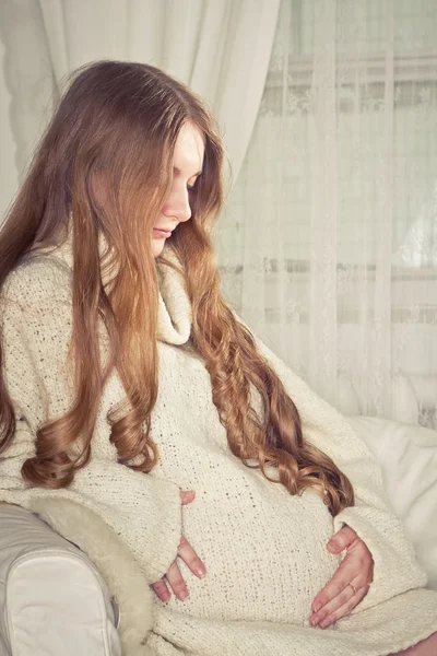 Pregnant woman sitting on sofa — Stock Photo, Image