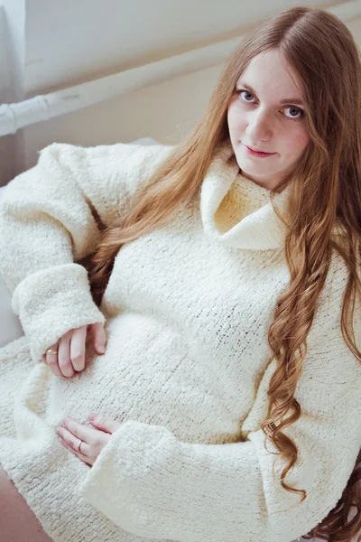 Schwangere Frau sitzt auf Sofa — Stockfoto