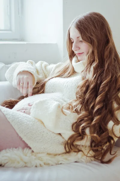 Zwangere vrouw zittend op de bank — Stockfoto