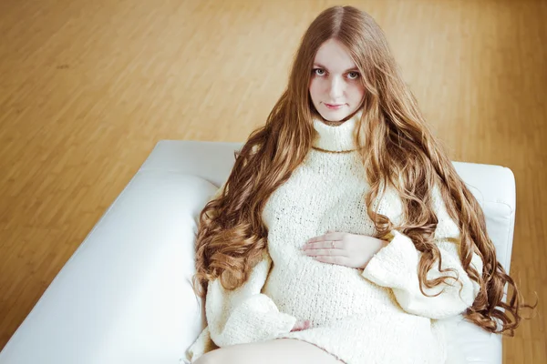 Pregnant woman sitting on sofa — Stock Photo, Image