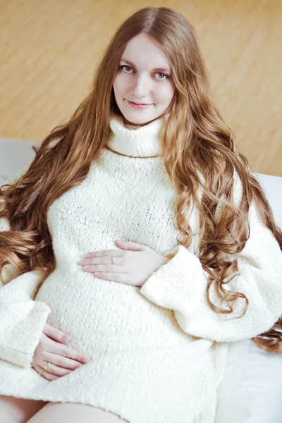 Pregnant woman sitting on sofa — Stock Photo, Image