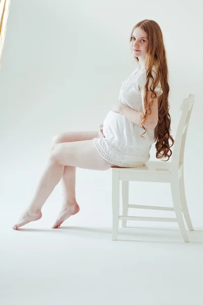 Mulher grávida sentada na cadeira — Fotografia de Stock