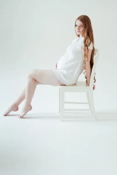 Pregnant woman sitting on chair — Stock Photo, Image