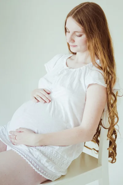 Gravid kvinna sitter på stol — Stockfoto