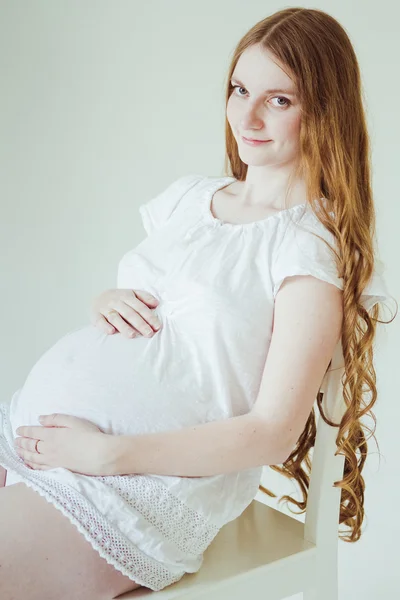 Donna incinta seduta sulla sedia — Foto Stock