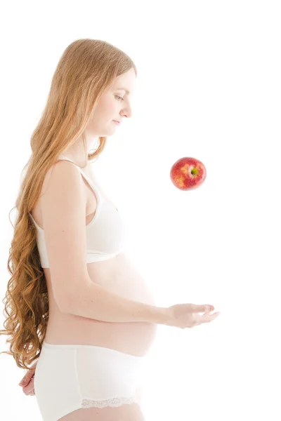 Беременная женщина с красным яблоком — стоковое фото