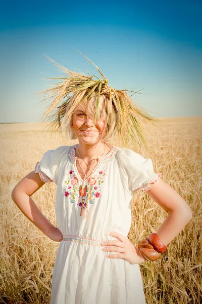 Bella ragazza in una tradizionale ghirlanda di slavi su un campo di grano dorato — Foto Stock