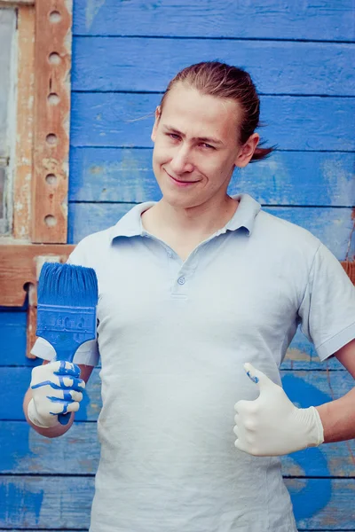 Man posing near house with painting brush — Stock Photo, Image