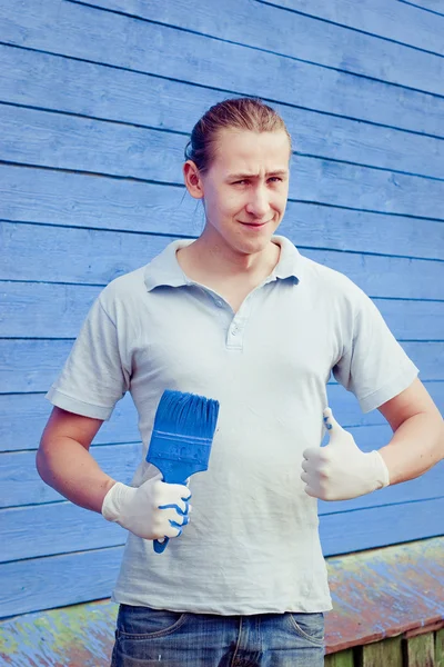 Homem posando perto de casa com pincel de pintura — Fotografia de Stock