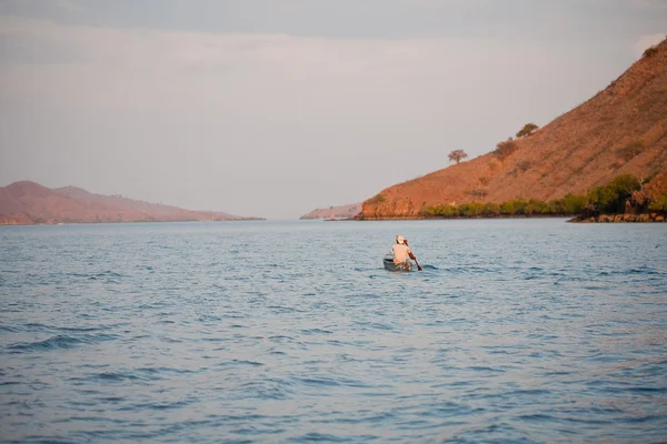 Homme flottant dans un bateau dans la mer — Photo