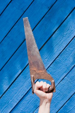 Mavi ahşap zemin üzerinde testere ile el