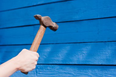 Mavi ahşap zemin üzerinde çekiç ile el