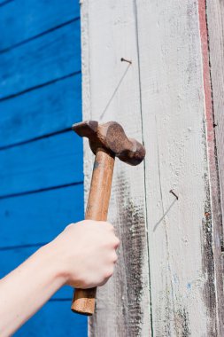 Mavi ahşap zemin üzerinde çekiç ile el