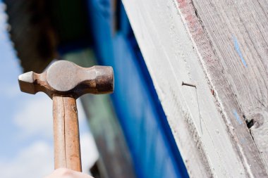 Mavi ahşap zemin üzerinde çekiç ile el