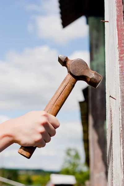 Hand with hammer on sky background — Stock Photo, Image