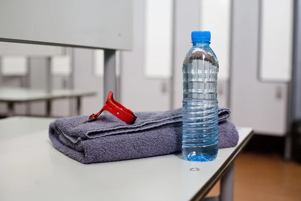 Láhev vody a ručník v šatně — Stock fotografie