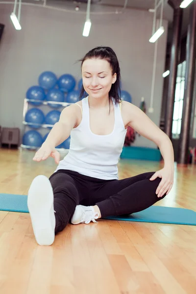 Mooie jonge doen oefening in een sportschool — Stockfoto