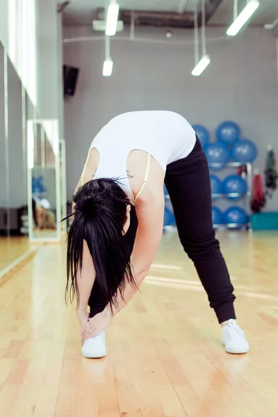 Hermosa joven haciendo ejercicio en un gimnasio — Foto de Stock
