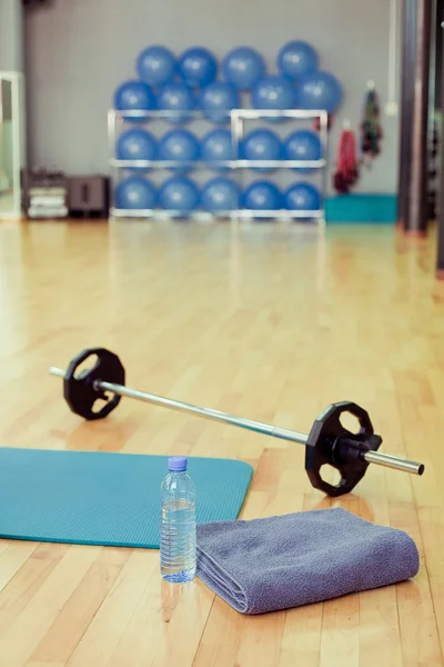 Flaska vatten, sportutrustning handduk och motion — Stockfoto