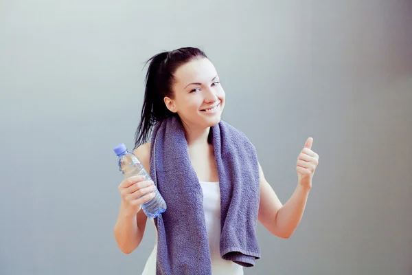 Jovem mulher bebendo água, no clube de fitness ou ginásio — Fotografia de Stock