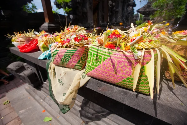 Offerings to gods in Bali with flowers, food and aroma sticks — Stock Photo, Image