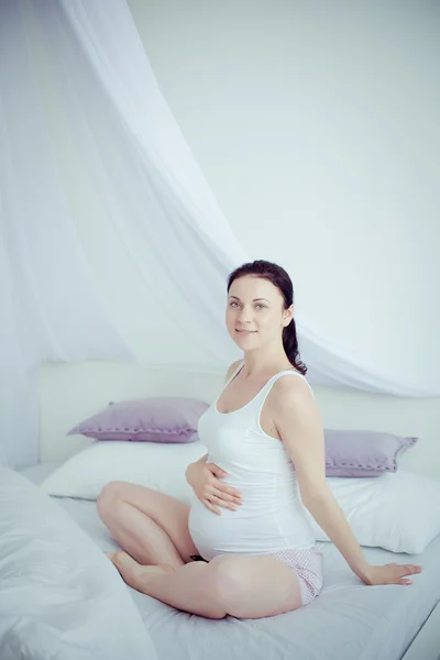 Mujer embarazada joven en el dormitorio —  Fotos de Stock