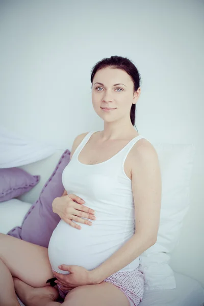 Mladá těhotná žena v ložnici — Stock fotografie