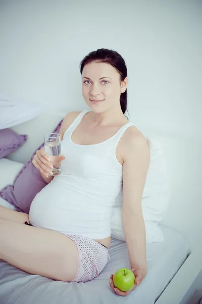 Jonge zwangere vrouw in de slaapkamer — Stockfoto