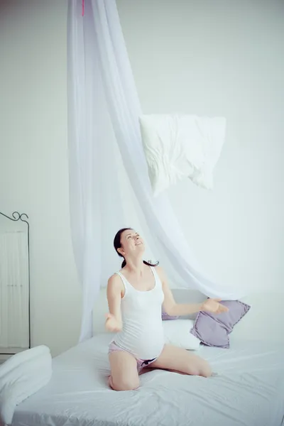 Молодая беременная женщина в спальне — стоковое фото