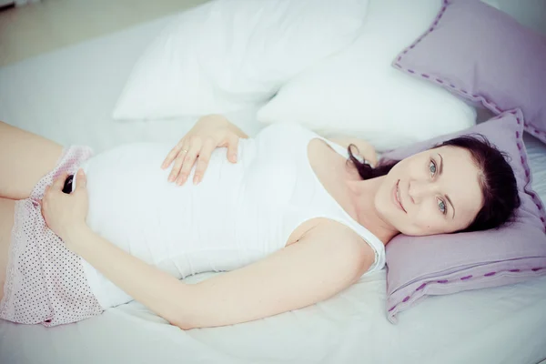 Junge schwangere Frau im Schlafzimmer — Stockfoto